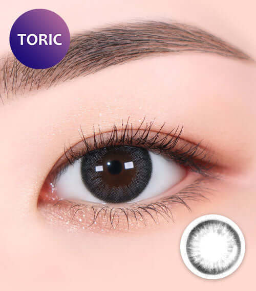 Close-up of an eye wearing Aida Gray toric contact lens with smokey gray color, enhancing gloss; ideal for a cool, mature look.