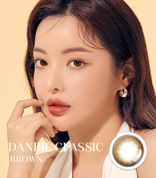 Model wearing Danbie Classic Brown toric lenses with natural look; 55% water content; replacement options available; Product ID: K015BR.