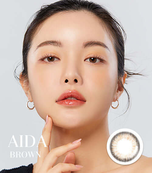 Model wearing Aida Brown toric circle lenses with delicate iris design and thin circle line, suitable for various replacement schedules.